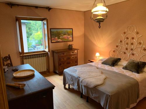 a bedroom with a bed and a table and a window at Snow peak in Ponte di Legno