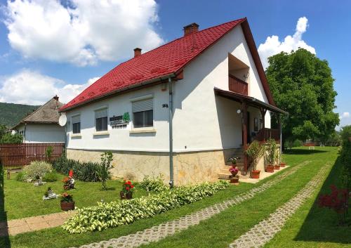 una pequeña casa blanca con techo rojo en Diókert Vendégház, en Komjáti
