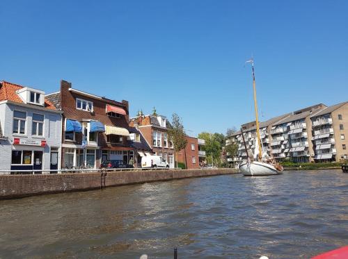 a boat sitting on a river in a city at De ferver in Leeuwarden