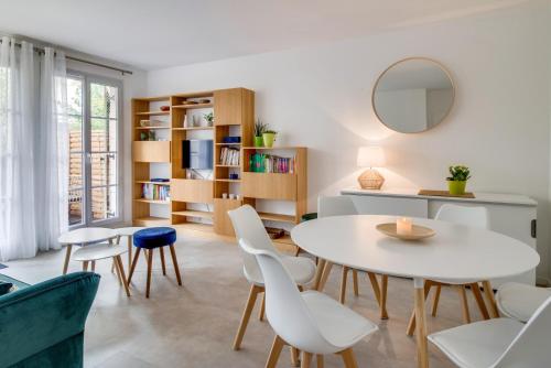 - un salon avec une table, des chaises et un miroir dans l'établissement M&M Ribeiro - Val d'Europe - Disneyland Paris - 4 à 7 Personnes, à Serris