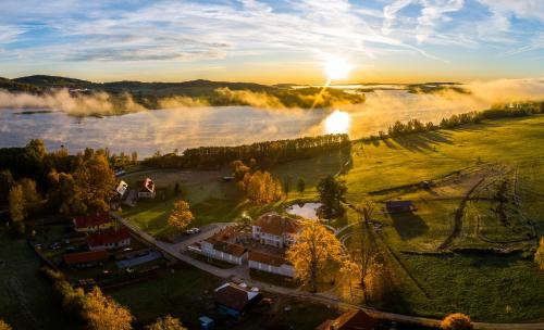 an aerial view of a village on a river with the sunset at Aparthotel & Wellness Knížecí cesta in Horní Planá