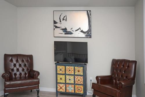 two leather chairs and a fireplace in a living room at Royal Stays Townhome Collection - 3 Bedroom Townhome in Oakville in Oakville
