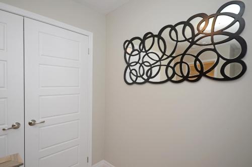 a metal sculpture hanging on a wall next to a door at Royal Stays Townhome Collection - 3 Bedroom Townhome in Oakville in Oakville