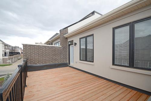a wooden deck on the side of a house at Royal Stays Townhome Collection - 3 Bedroom Townhome in Oakville in Oakville