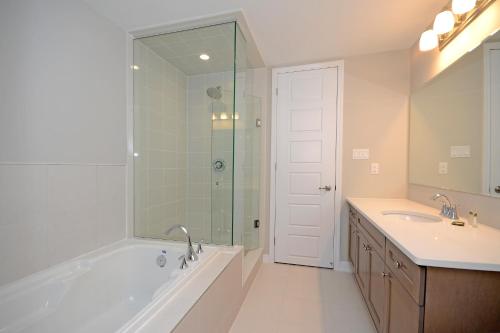 a bathroom with a tub and a sink and a shower at Royal Stays Townhome Collection - 3 Bedroom Townhome in Oakville in Oakville