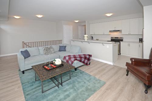 a living room with a couch and a table and a kitchen at Royal Stays Townhome Collection - 3 Bedroom Townhome in Oakville in Oakville