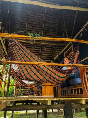 a person laying in a hammock on a table at Amazon Muyuna Lodge - All Inclusive in Paraíso
