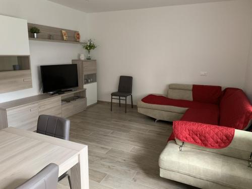 ein Wohnzimmer mit einem Sofa und einem TV in der Unterkunft Casa Chiara Andalo Centro in Andalo