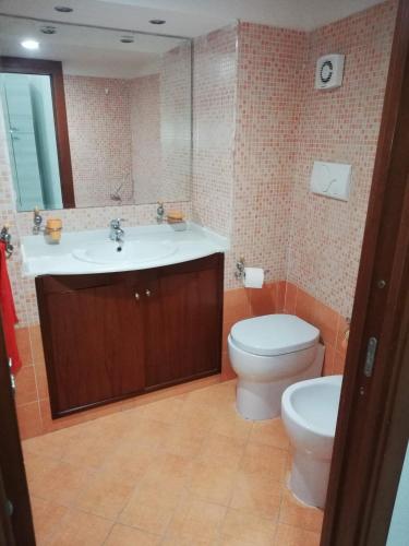 bagno con lavandino, servizi igienici e specchio di Aurora Apartment nel cuore di Napoli a Napoli