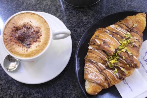 een bord met een kopje koffie en een gebakje bij Relais del Corso in Manfredonia
