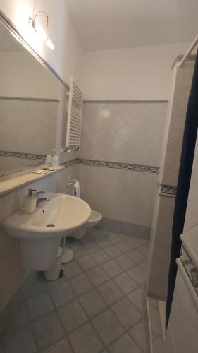a white bathroom with a sink and a mirror at Guest house Le Sibille in Taormina