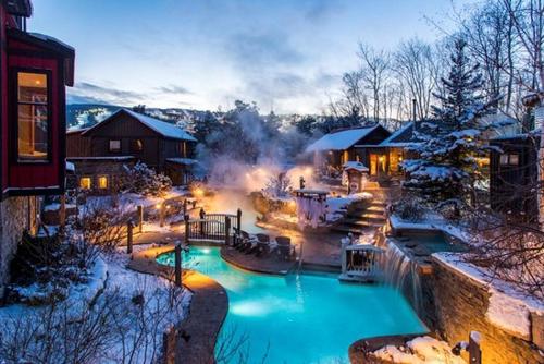 a snow covered yard with a swimming pool at The Blue Escape Blue Mountain Chalet in Blue Mountains
