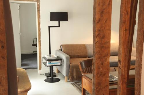 a living room with a couch and a lamp at Bail mobilité appartement Louvre Palais Royal in Paris