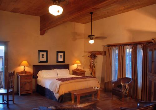 a bedroom with a bed and two tables and chairs at The Maverick Inn in Alpine