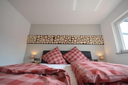 a bedroom with two beds with red and white sheets at Apartment Keuerleber in Holzmaden