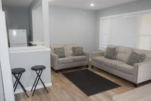 a living room with two chairs and a couch and a tv at Dahl's Motel in Oroville