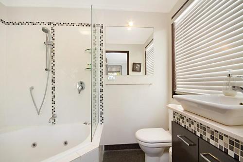 y baño con ducha, aseo y lavamanos. en Villas at Hastings Point by Kingscliff Accommodation en Hastings Point