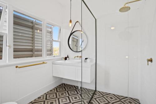 a white bathroom with a sink and a mirror at Hideaway on Keats - Keats Street, Byron Bay in Byron Bay