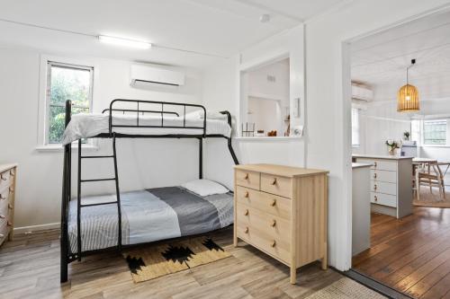 a bedroom with a bunk bed and a kitchen at Hideaway on Keats - Keats Street, Byron Bay in Byron Bay