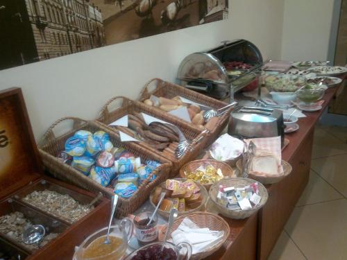 a buffet with baskets of food on a table at H6 MAJOR ApartHotel Travel & Business, FREE PARKING in Kraków