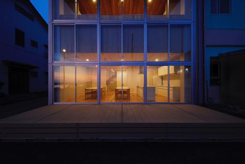 a building with a large window with a table inside at 渚泊魚津丸 in Motoshin