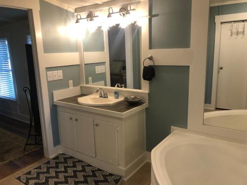 W łazience znajduje się umywalka, toaleta i lustro. w obiekcie Beaufort SC New Renovation, Close to Parris Island, Historic Downtown, Beautiful Beaches, Sleeps 8 w mieście Beaufort