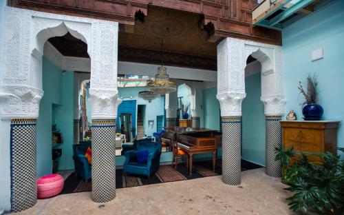 uma sala de estar com paredes azuis e um piano de cauda em Dar anne em Fez