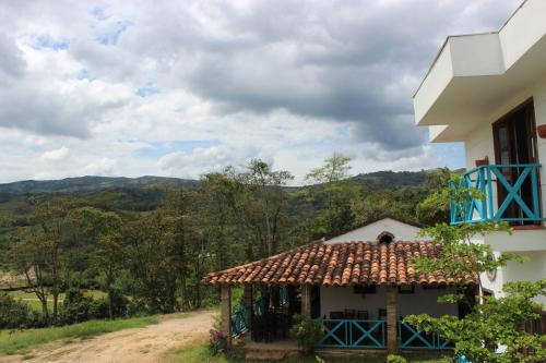 a house with a tile roof on a dirt road at Hotel la hacienda del pienta in Charalá