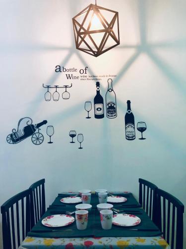 a table with wine bottles and glasses on a wall at CozySoho-Cyberjaya,Netflix provided,fit 5pax in Cyberjaya