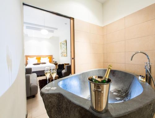 a bath tub in a room with a bedroom at Hôtel Spa Marotte in Amiens