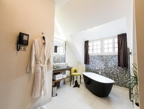 a bathroom with a black tub and a shower at Hôtel Spa Marotte in Amiens