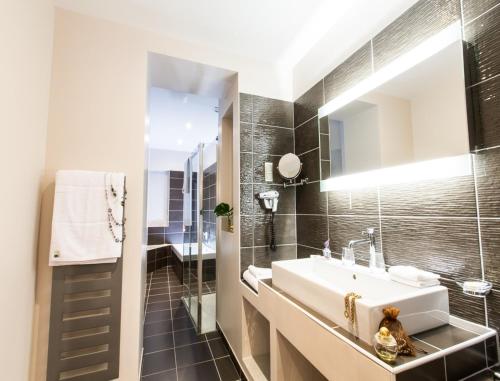 a bathroom with a sink and a mirror at Hôtel Spa Marotte in Amiens