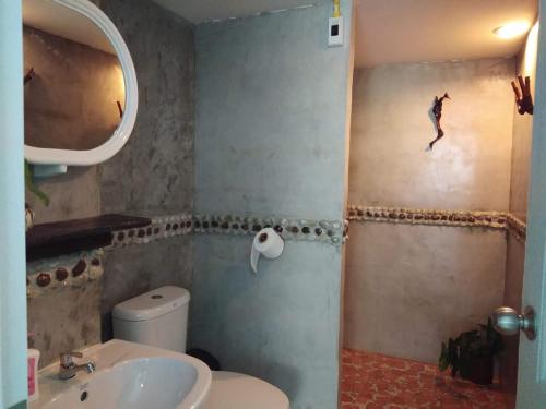 a bathroom with a sink and a toilet and a mirror at Green Home in Khao Lak