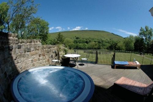 a bath tub in a yard with a patio at Losehill House Hotel & Spa in Hope