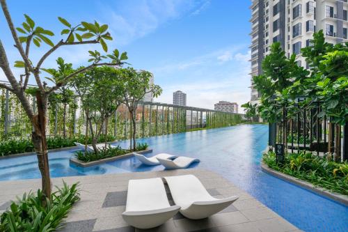 a swimming pool in a building with two white benches at HighPark Suites in Petaling Jaya, Kelana Jaya by Plush in Kampong Baharu Sungai Way