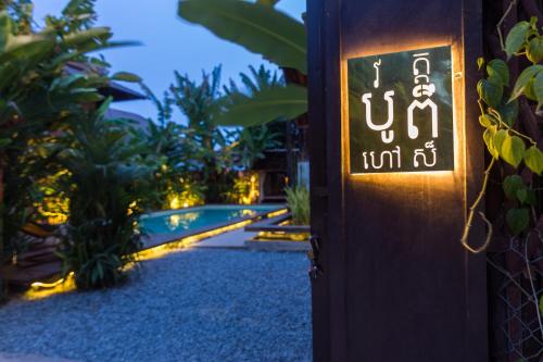 a sign on the side of a building with lights at Wat Bo House in Siem Reap
