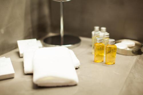a counter with two bottles of oil and towels at Hotel Hemera in Podgorica