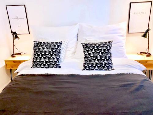 a bed with two black and white pillows on it at Old Town Apartment-City Centre in Warsaw