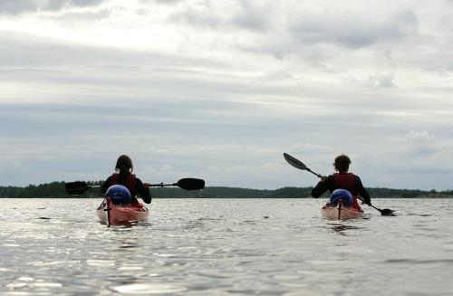 two people in kayaks on a body of water at Hasselö Hostel in Hasselö