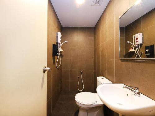 a bathroom with a toilet and a sink at The Fern Lodge Hotel in Skudai