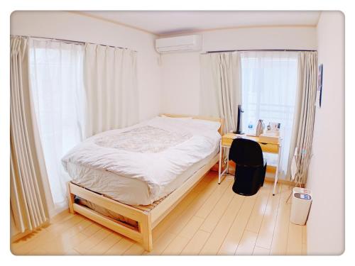 东京Hao Bros. Home的带床、书桌和窗户的卧室