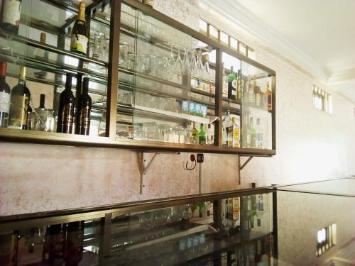 ロメにあるStone Hotelのボトルとグラスを壁に貼ったバー