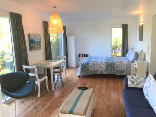 a bedroom with a bed and a table and a couch at Studio 531 in Coromandel Town