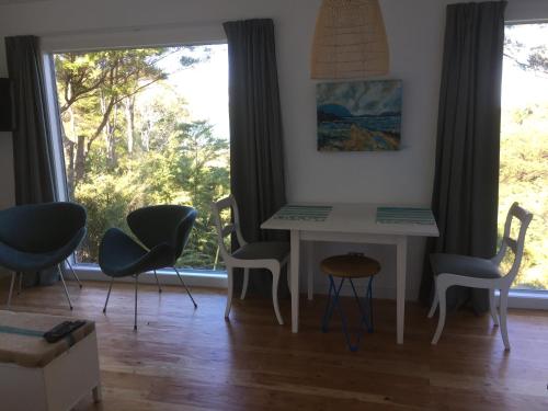 a table and chairs in a room with a window at Studio 531 in Coromandel Town