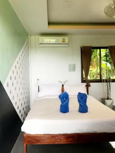 a bedroom with a bed with blue cushions on it at Lanta Halabala Resort in Ko Lanta
