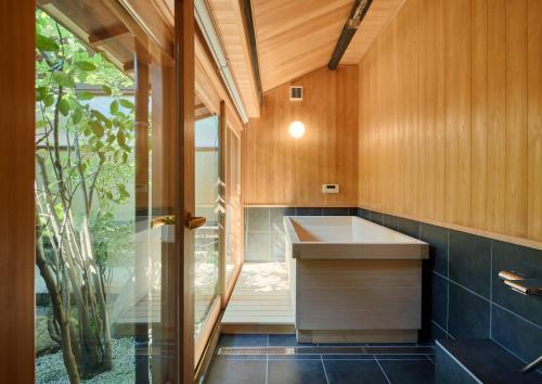 a bathroom with a sink and a window in it at Tomonoura Shiomachi Hotel in Fukuyama