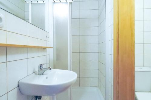 een witte badkamer met een wastafel en een douche bij Penzion Lyžec in Vrchlabí