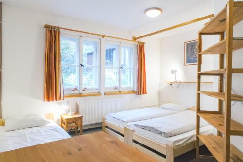 1 dormitorio con 2 camas y escalera en Penzion Lyžec, en Vrchlabí