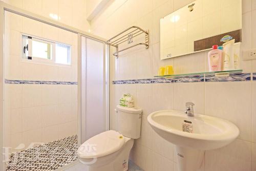 a bathroom with a toilet and a sink at Penghu Color FIsh Homestay in Huxi