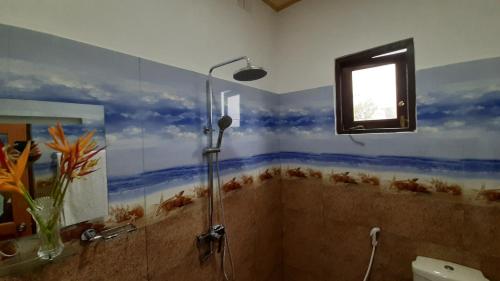 a bathroom with a shower with blue walls and a window at Bandulas Beach House in Hikkaduwa